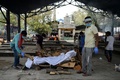 インドの首都ニューデリーにある火葬場で、コロナ犠牲者の遺体を燃やす準備をする作業員と遺族（2020年6月3日撮影）。(c)AFP/Sajjad  HUSSAIN