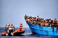 リビア沖で行われた救助活動で、難民・移民を落ち着かせようとするスペインのNGO「プロアクティバ・オープン・アームズ」のメンバーら（2016年10月4日撮影）。(c)AFP/Aris Messinis