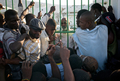 ハイチの首都ポルトープランス（Port-au-Prince）で、崩壊した大統領官邸のフェンスの内側から集まった市民と語るルネ・プレバル（Rene Preval）ハイチ大統領（奥、2010年1月30日撮影）。(c)AFP/JEAN-PHILIPPE KSIAZEK
