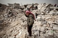戦闘で荒廃したシリア北部の都市アレッポ（Aleppo）のTariq al-Bab地区で、自宅のがれきにたたずむ男性（2013年2月23日撮影）。(c)AFP/PABLO TOSCO