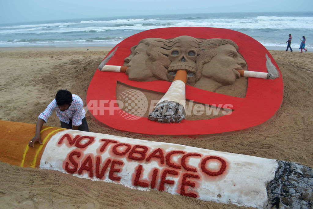 百害あって一利なし 砂のアートで禁煙メッセージ インド 写真1枚