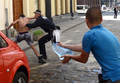 写真はウクライナ西部リビウ（Lviv）で若い女性に水をかけた男性を逮捕しようとする警察官と、警察官に向かって水をかけようとする青年（2013年5月6日撮影）。(c)AFP/YURIY DYACHYSHYN