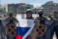 ロシア国旗を手にする民間軍事会社ワグネルの創設者、エフゲニー・プリゴジン氏（中央）。ウクライナ・バフムートで。ワグネルの関連会社コンコルドがテレグラムに投稿した動画より（2023年5月20日公開）。(c)AFP PHOTO / Telegram channel of Concord group 