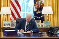 米ホワイトハウスの大統領執務室で、経済対策法案に署名するジョー・バイデン大統領（2021年3月11日撮影）。(c)MANDEL NGAN / AFP