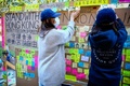 豪ブリスベンのクイーンズランド大学で、いわゆる「レノンウォール」にメッセージをはる香港民主派デモの支持者ら（2019年8月9日撮影）。(c)Patrick HAMILTON / AFP