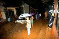 インドネシアの中ジャワ州ブレブス県で、土砂崩れの発生で泥に覆われた通りを歩く住民ら（2018年2月22日撮影）。(c)AFP