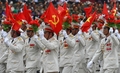 ベトナム・ハノイ（Hanoi）で行われた軍事パレードに参加し、ホーチミン廟の前で旗を振る退役軍人ら（2010年10月10日撮影）。(c)AFP/HOANG DINH Nam