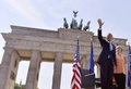 ドイツ首都ベルリン（Berlin）のブランデンブルク門（Brandenburg Gate）前に集まった人々に手を振るバラク・オバマ（Barack Obama）米大統領（左）とアンゲラ・メルケル（Angela Merkel）独首相（右、2013年6月19日撮影）。(c)AFP/JEWEL SAMAD