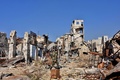 シリア北部アレッポ市内で、がれきの中を歩く政府軍側の戦闘員（2016年12月9日撮影）。(c)AFP/George OURFALIAN