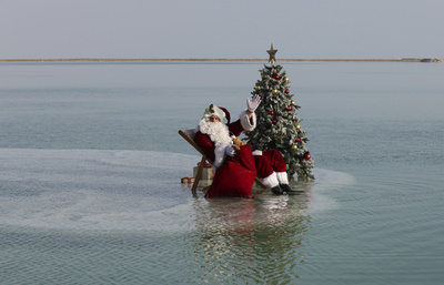 死海に浮かぶサンタ？ 塩の「浜辺」でリラックス