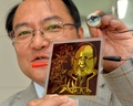 フランソワ・オランド(Francois Hollande)仏大統領をモチーフにした柄の太陽電池の試作品を手にする、東京大学（University of Tokyo）先端科学技術研究センター（Centre for Advanced Science）の瀬川浩司（Hiroshi Segawa）教授（2014年7月24日）。(c)AFP/Yoshikazu TSUNO