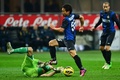 12-13イタリア・セリエA第24節、インテル（Inter Milan）対キエーボ・ベローナ（Chievo Verona）。キエーボ・ベローナのGKクリスティアン・プッジョーニ（Christian Puggioni、左下）とボールを競るインテルの長友佑都（Yuto Nagatomo、2013年2月10日撮影）。(c)AFP/GIUSEPPE CACACE