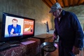 仏中部シャルトル近郊の農場で、エマニュエル・マクロン大統領の国民向けテレビ演説を見る農家の男性（2021年3月31日撮影）。(c)JEAN-FRANCOIS MONIER / AFP