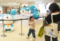 ドラえもんのフィギュアの前で記念写真を撮る子ども（2025年3月28日撮影）。(c)Xinhua News
