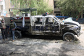 イラクの首都バグダッド（Baghdad）で起きた自動車爆弾攻撃の現場で、損傷した車を調べる警察官（2013年5月30日撮影）。(c)AFP/AHMAD AL-RUBAYE