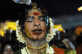 シンガポールで30日、ヒンズー教の大祭タイプーサム（Thaipusam）が行われた。ムルガ（Muruga）神をあがめるこの祭りは、 タミル暦のタイ（Thai）の月の満月の日に行われる。信者らは「カバディ（Kavadi）」と呼ばれる御輿（みこし）を鉄串などで自分の身体に固定して苦行の行進を行う。この祭りはマレーシアでも行われる。

写真は、夜明け前のマレーシア・クアラルンプール（Kuala Lumpur）で、バトゥ洞窟（Batu cave）のヒンズー教寺院に向かう行進の途中、隣に立った男性（フレーム外）から頭に水を掛けられるヒンズー教徒（2010年1月30日撮影）。(c)AFP/Saeed KHAN