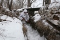 ウクライナ東部ドネツク州ベルヒノトレーツケ村付近の親ロシア分離独立派との前線で、雪に覆われた塹壕を歩くウクライナの兵士（2022年2月1日撮影）。(c)Anatolii STEPANOV / AFP