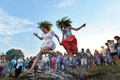 伝統的なスラブ民族の祭り「イワン・クパーラ（Ivan Kupala）の夜」が6日、東欧各地で行われた。起源をキリスト教以前にまでさかのぼるというこの祭りでは、人々が花輪を編んだり、たき火を飛び越えたり、裸で泳いだりして祝う。

写真はウクライナの首都キエフ（Kiev）近郊で、たき火を飛び越える人々（2013年7月6日撮影）。(c)AFP/SERGEI SUPINSKY