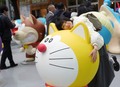 「耳付きドラえもん」像と写真に収まる少女（2025年3月28日撮影）。(c)Xinhua News