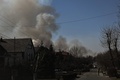 ウクライナの首都キエフ北方で爆撃による煙が立ち上る中、検問所で警備を行うウクライナ兵（2022年3月19日撮影）。(c)Aris Messinis / AFP