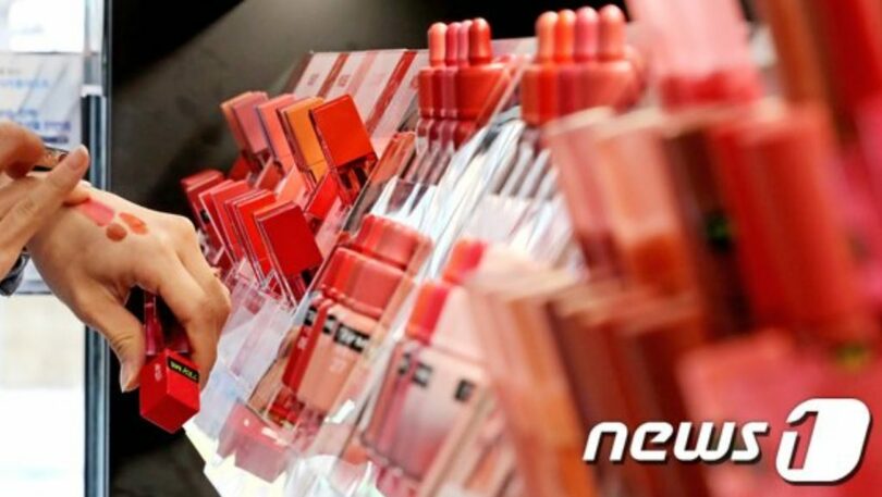 オリーブヤングの売り場で化粧品を直接肌に塗って比較する買い物客(c)news1