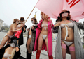 ウクライナの女性活動団体FEMENが9日、首都キエフ（Kiev）の独立広場（Independence Square）で、マスクで作った下着を身に付け抗議行動を行った。FEMENは、2010年1月の大統領選挙を前に、政府や他の政治団体が新型インフルエンザを利用して恐怖心をあおっていると主張している（2009年11月9日撮影）。(c)AFP/SERGEI SUPINSKY
