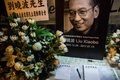 劉暁波氏の死去を受け、中国・香港の中央政府駐香港連絡弁公室に設けられた記帳台と劉氏の写真（2017年7月13日撮影）。(c)AFP/Isaac Lawrence