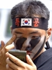 ソウル（Seoul）の北にある抱川（Pochon）軍事基地で、テコンドーの親善試合前、顔に化粧を直す特殊部隊員。（2003年7月11日撮影）(c)AFP/KIM JAE-HWAN