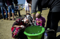 キャンプで、バケツを使って娘の髪を洗う母親。(c)AFP/Bulent Kilic