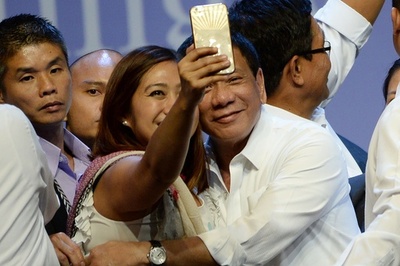 強面のドゥテルテ比大統領、笑顔でセルフィーに応じる
