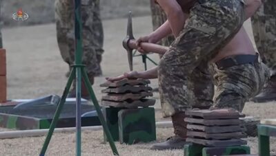 釘の上にうつ伏せ、背中の石板を砕かせる…北朝鮮・特殊部隊が極限的な過激「破壊」演武、忠誠と戦闘力誇示