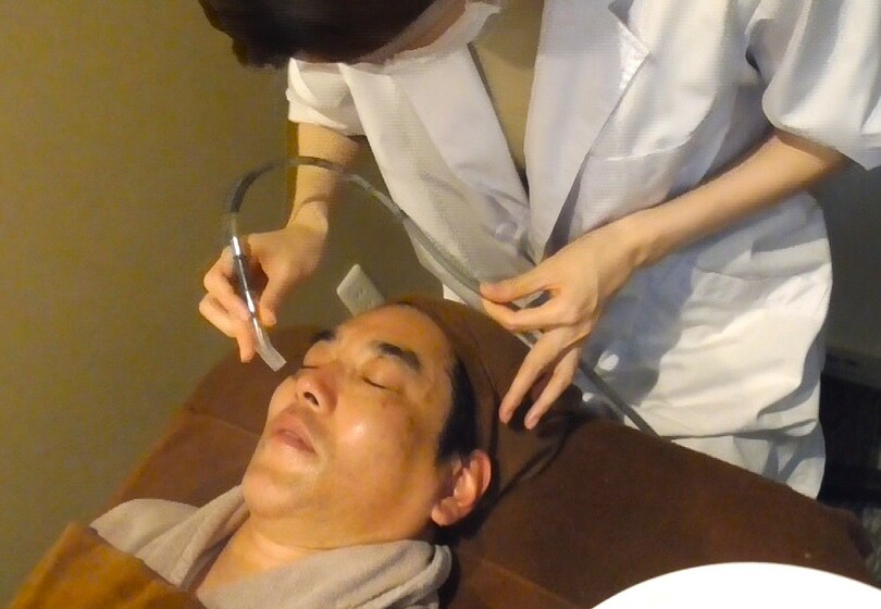 吸引機を使って顔の表面に浮き出た物質を吸い取る様子(c)KOREA WAVE