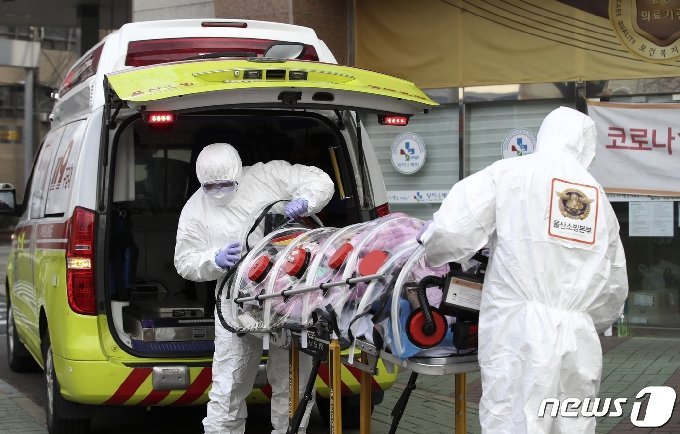 新型コロナ感染者を運ぶ救急隊員(c)news1