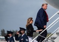 米フロリダ州のパームビーチ空港で、大統領専用機「エアフォースワン」に乗り込むドナルド・トランプ大統領（右）と妻のメラニア氏（中央、2020年12月31日撮影）。(c)ANDREW CABALLERO-REYNOLDS / AFP