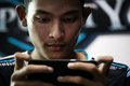 ミャンマー・ヤンゴンで、携帯電話でゲームに参加するeスポーツ選手のミン・ミャ・アウンさん（2019年8月19日撮影）。(c)Sai Aung MAIN / AFP