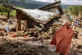 鉄砲水や地滑りで破壊された家屋のそばを歩く女性。ケニア・マイマヒウで（2024年4月30日撮影）。(c)LUIS TATO / AFP