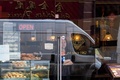 英ロンドンの中華街にある飲食店から外を眺める従業員（2020年2月4日撮影）。(c)JUSTIN TALLIS / AFP