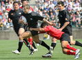 写真は、日本代表の安藤栄次（%%Eiji Ando%%）のタックルを振り切るクラシック・オールブラックスのカルロス・スペンサー（%%Carlos Spencer%%）。(c)AFP/KAZUHIRO NOGI