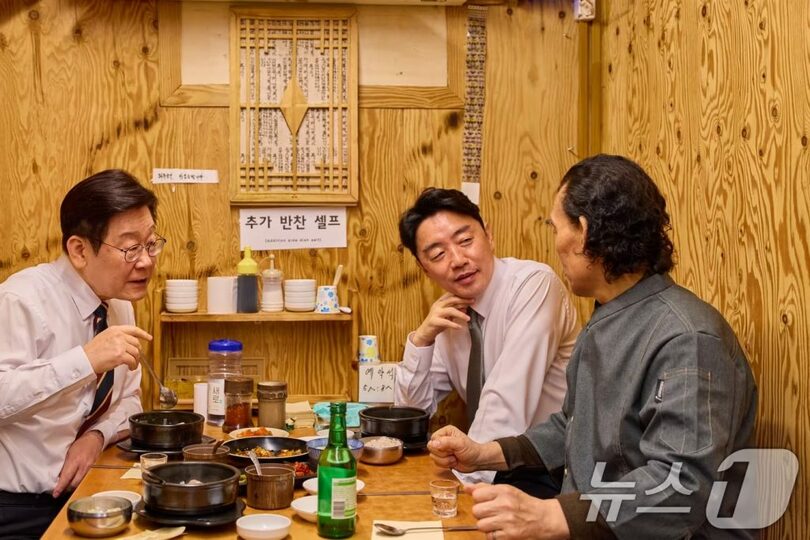 9日、ソウル市鍾路区の通仁市場にある飲食店で商人と話しながら食事をする韓国のイ・ジェミョン（李在明）大統領(c)news1