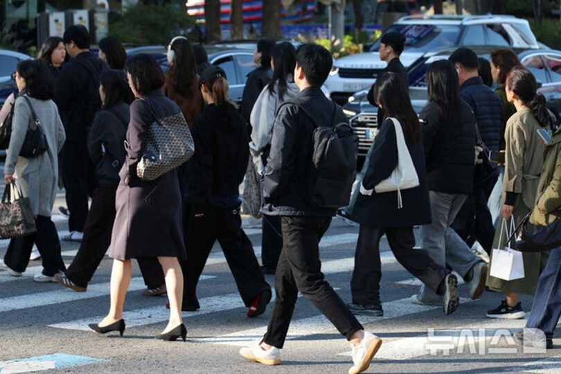 冷え込みが厳しくなった朝、ソウル・光化門交差点で出勤を急ぐ会社員たち＝2026年10月22日(c)NEWSIS