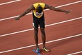 第16回世界陸上ロンドン大会、男子4×100メートルリレー決勝。レース後、頭を下げて歓声に応えるジャマイカのウサイン・ボルト（中央、2017年8月12日撮影）。(c)AFP/Glyn KIRK