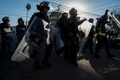 メキシコ北部ティフアナで、中米からの移民らが滞在している地点近くで警備に当たる警察官ら（2018年11月26日撮影）。(c)Guillermo Arias / AFP
