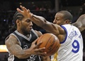 15-16NBA、サンアントニオ・スパーズ対ゴールデンステイト・ウォリアーズ。ゴールデンステイト・ウォリアーズのアンドレ・イグダーラをかわすサンアントニオ・スパーズのカウィ・レナード（2016年4月10日撮影）。(c)AFP/Getty Images/Ronald Cortes