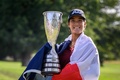 女子ゴルフ米国ツアーメジャー第4戦、アムンディ・エビアン選手権最終日。フランス国旗を肩にかけ、トロフィーを手にポーズをとるセリーヌ・ビュティエ（2023年7月30日撮影）。(c)Fabrice COFFRINI / AFP