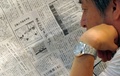 都内で、仏紙が掲載した風刺画について報じる日本の新聞記事を読む人（2013年9月12日撮影）。(c)AFP/KAZUHIRO NOGI