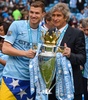 13-14イングランド・プレミアリーグ最終第38節、マンチェスター・シティ（Manchester City）対ウェストハム（West Ham）。トロフィーを手にカメラに向けポーズを取るマンチェスター・シティのエディン・ジェコ（Edin Dzeko、左）とマヌエル・ペジェグリーニ（Manuel Pellegrini）監督（2014年5月11日撮影）。(c)AFP/ANDREW YATES