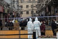 中国・上海の黄浦区で、隔離対象となった住宅街周辺を封鎖する防護服姿の警察官ら（2021年1月21日撮影）。(c)STF / AFP