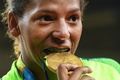 リオデジャネイロ五輪、柔道女子57キロ級。優勝を飾り、金メダルをかむラファエラ・シルバ（2016年8月8日撮影）。(c)AFP/Toshifumi KITAMURA