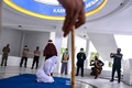インドネシア・アチェ州のバンダアチェで、公開むち打ち刑を受ける女性（中央、2021年7月8日撮影）。(c)CHAIDEER MAHYUDDIN / AFP