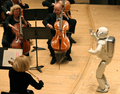 米ミシガン（Michigan）州デトロイト（Detroit）で行われたコンサートで、デトロイト交響楽団（Detroit Symphony Orchestra）を指揮するホンダの2足歩行ロボット「ASIMO」。（2008年5月13日撮影、ホンダ提供）(c)AFP/HONDA